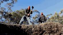 a man with a red face is holding an axe and another man with a black jacket is standing behind him