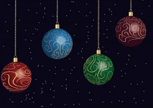 four different colored christmas ornaments hanging from chains on a dark background