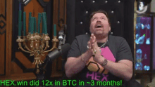 a man sitting in front of a microphone with the words " hex win did 12x in btc in 3 months "