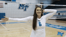 a middle tennessee volleyball player stands in front of the net