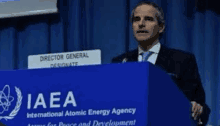 a man is standing at a podium giving a speech at a conference .