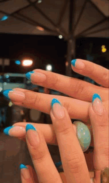 a close up of a person 's nails with a blue french manicure