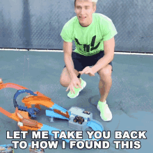 a man in a green shirt is kneeling down in front of a toy track that says let me take you back