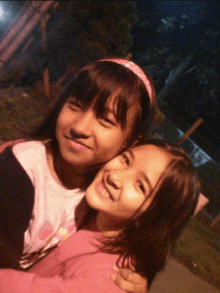 two young girls are posing for a picture and one has a pink headband