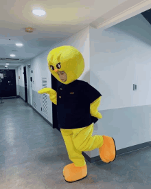 a person dressed in a yellow mascot costume with a black shirt