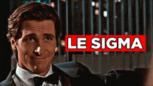 a man in a suit and bow tie is smiling in front of a red sign that says le sigma