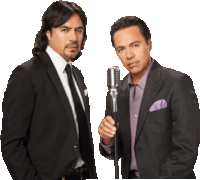 two men in suits and ties standing next to each other holding a microphone