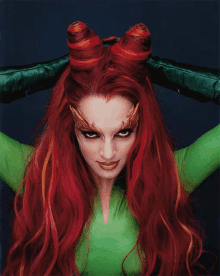 a woman with red hair is wearing a green costume