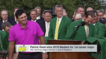 a man in a pink shirt is standing in front of a podium with the words patrick reed wins 2018 masters for 1st career major