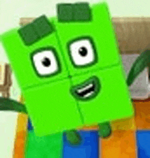 a green block with white eyes and a smiling face is standing on a bed .