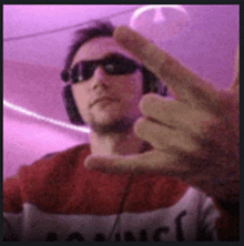 a man wearing sunglasses and headphones is making a peace sign