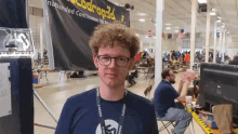 a man wearing glasses stands in front of a banner that says ' nattended continuous 3d printing ' on it