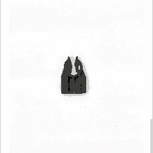 a black plastic clip on a white surface .