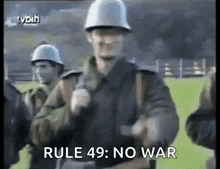 a group of soldiers are walking on a field and one of them is wearing a helmet and says rule 49 : no war