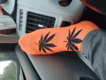 a pair of orange socks with black marijuana leaves