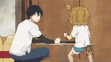 a man and a girl are sitting at a table with their fists up