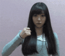 a woman with long hair is making a fist