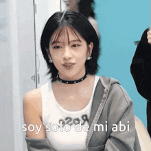 a woman wearing a choker and a tank top says " soy solo de mi abi "