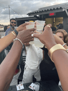 a group of people are toasting with drinks in front of a sign that says " exit "