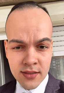 a close up of a man 's face with a very short haircut