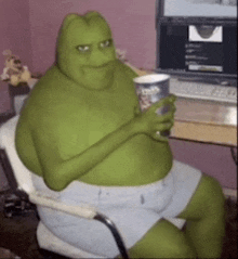 a person dressed as shrek is sitting in a chair holding a cup of coffee .