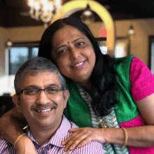 a man and woman are posing for a picture and the woman is wearing a green shirt