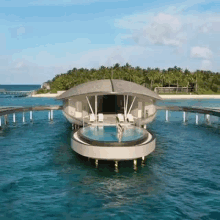 an aerial view of a floating house with a swimming pool in the ocean .