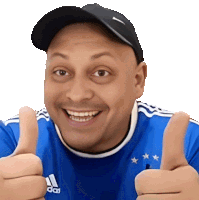 a man wearing a blue adidas shirt is giving a thumbs up