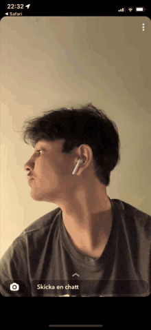 a phone screen shows a man wearing ear buds and a safari icon