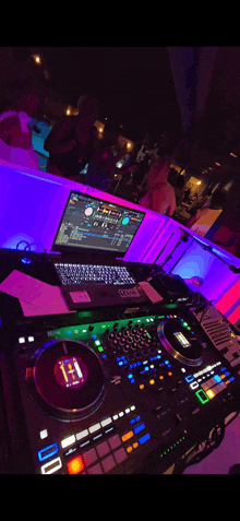 a dj 's setup with a laptop and a controller that says h1 on it