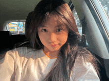 a girl taking a selfie in a car with a sign in the background that says ' a '