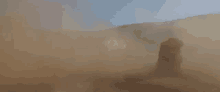 a person is standing in the middle of a dust storm in the desert .