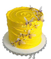 a yellow cake decorated with butterflies and pearls has the letters ac on it