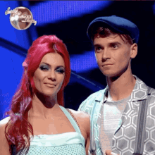 a man and a woman are standing next to each other in front of a sign that says strictly come dance