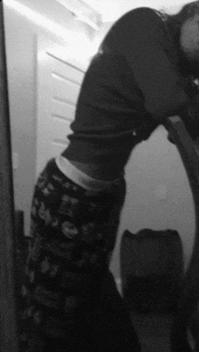 a black and white photo of a person wearing pajama pants