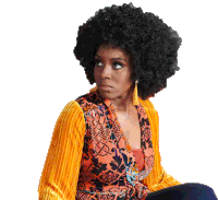 a woman wearing a large afro wig and earrings looks to the side