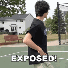 a man in a black shirt is standing on a basketball court with the word exposed written in white letters