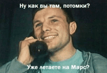 a man is smiling while talking on a cell phone in russian .