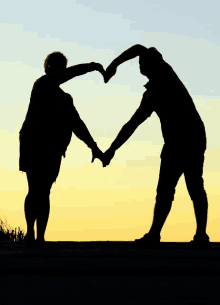 a couple making a heart with their hands