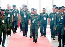 a group of military men are walking on a red carpet .