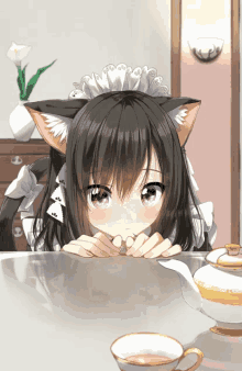 a girl with cat ears is sitting at a table with a cup of tea