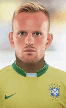 a man with a beard wears a yellow shirt that says brasil on the front