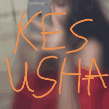 a woman taking a picture of herself with the words kes usha written on it