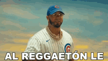 a man wearing a chicago cubs baseball uniform and a blue hat is standing in front of a blue sky .