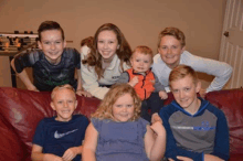 a group of kids are posing for a picture on a red couch