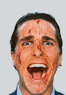 a man with blood on his face has his mouth open