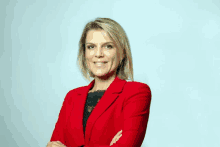 a woman wearing a red jacket with her arms crossed