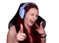 a woman with red hair is wearing headphones and giving a thumbs up