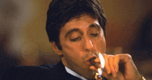 a man in a tuxedo is smoking a cigar with his eyes closed