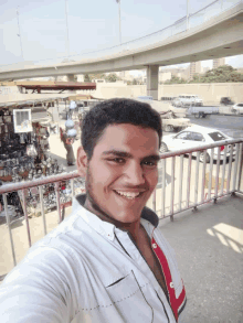 a man taking a selfie in front of a fence with a sign on it that says ' dubai '